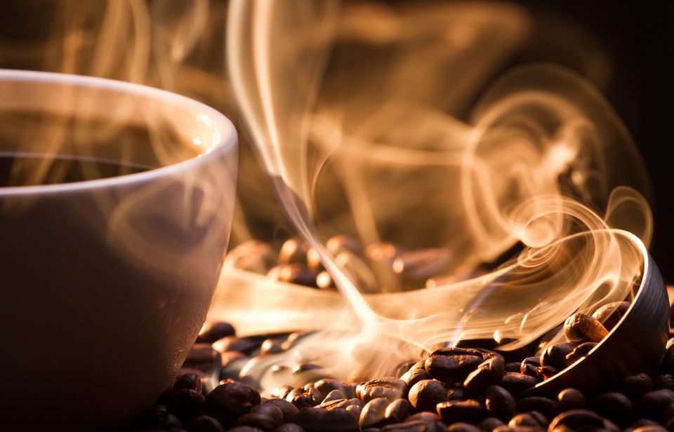 A cup of coffee with rising steam that creates an inviting and cozy atmosphere